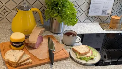 a sandwich on a cutting board and a plate of food at Avenue Apartments in Kaunas