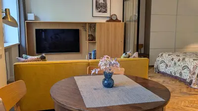 a living room with a couch and a table with flowers at Avenue Apartments in Kaunas