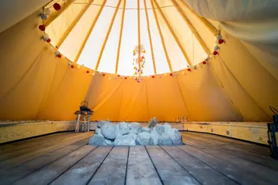 a tent with chairs in the middle of a wooden floor at Briedžio sapnas in Sudervė