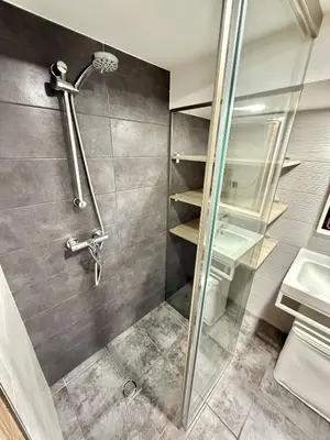 a shower with a glass door in a bathroom at Urban Breeze Kaunas in Kaunas