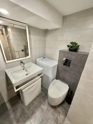 a bathroom with a white toilet and a sink at Urban Breeze Kaunas in Kaunas