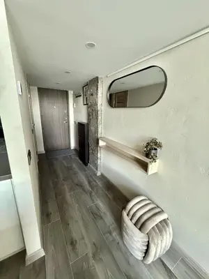 a hallway with a large mirror and a stool at Urban Breeze Kaunas in Kaunas