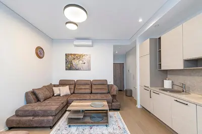 a living room with a couch and a table at Saulės Sonata apartamentai 5 in Druskininkai
