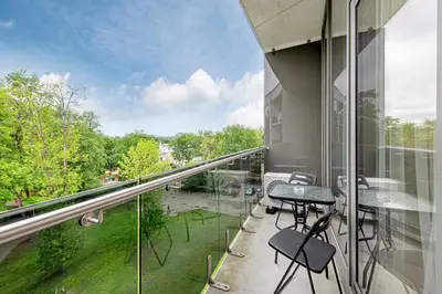a balcony with chairs and tables on a building at Saulės Sonata apartamentai 5 in Druskininkai