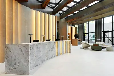 a lobby with a marble reception desk and chairs at AC Hotel by Marriott Vilnius in Vilnius