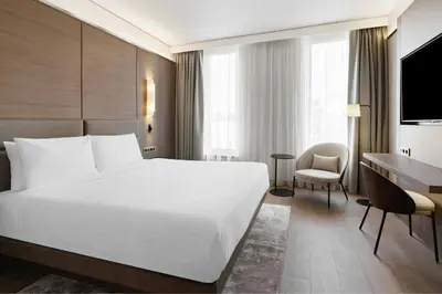 a hotel room with a large white bed and a desk at AC Hotel by Marriott Vilnius in Vilnius
