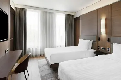 a hotel room with two beds and a desk at AC Hotel by Marriott Vilnius in Vilnius