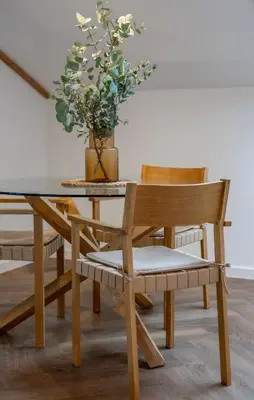 a dining room table and chair with a potted plant at Griunvaldo apartamentai in Kaunas