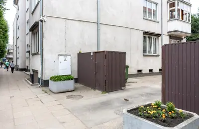 an empty street with a fence and some flowers at Griunvaldo apartamentai in Kaunas