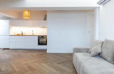 a living room with a couch and a kitchen at Griunvaldo apartamentai in Kaunas