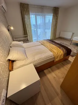 a bedroom with a large bed and a table at Florina namai in Marijampolė
