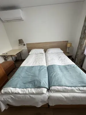 a bedroom with a large bed and a desk at Florina namai in Marijampolė