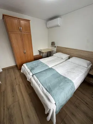 a bedroom with a large bed and a wooden cabinet at Florina namai in Marijampolė