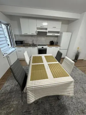 a kitchen with a table and chairs in a room at Florina namai in Marijampolė