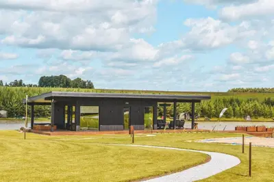 a modern house with a black roof at Vilkiškių Karpis Glamping in Vilionys