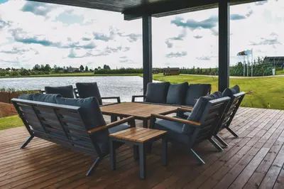 a wooden deck with a wooden table and chairs at Vilkiškių Karpis Glamping in Vilionys