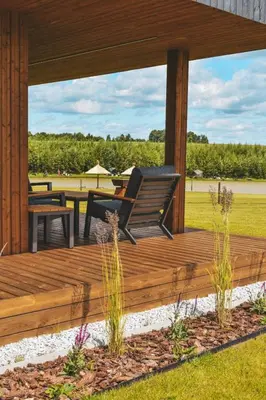 a wooden deck with a bench and a table at Vilkiškių Karpis Glamping in Vilionys