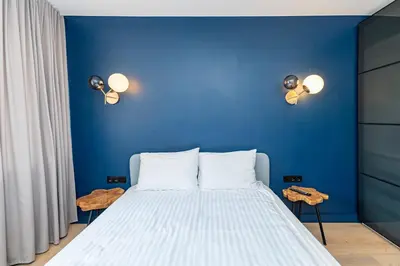 a blue bedroom with a bed with blue walls at 2-BD Apartment Winery by Polo Apartments in Kaunas