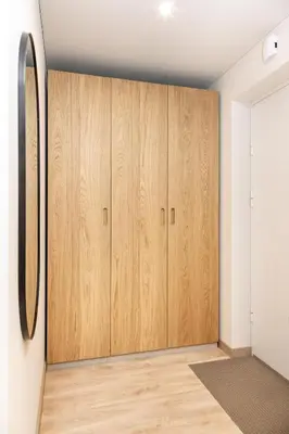 a room with wooden cabinets and a mirror at Jaukus poilsis Birštone in Birštonas