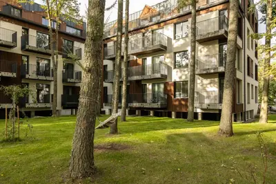 an apartment building with trees in front of it at Jaukus poilsis Birštone in Birštonas