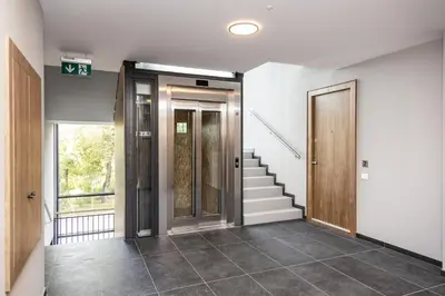 a hallway with a door and stairs in a building at Jaukus poilsis Birštone in Birštonas