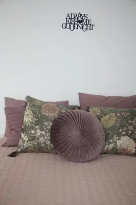 a bunch of pillows on a bed with at Central Kaunas Apartment in Kaunas