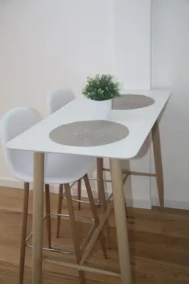 a white table and chairs with a potted plant on it at Central Kaunas Apartment in Kaunas