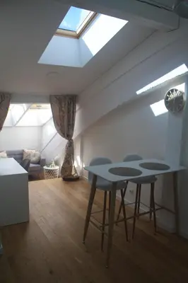 a living room with two tables and a skylight at Central Kaunas Apartment in Kaunas