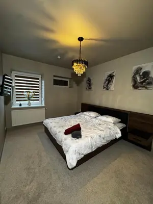 a bedroom with a large bed and a chandelier at Oscuro Deseo BDSM in Kaunas