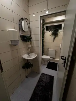 a small bathroom with a sink and a toilet at Oscuro Deseo BDSM in Kaunas