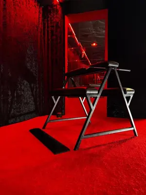 a black chair sitting on a red carpet at Oscuro Deseo BDSM in Kaunas