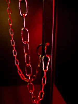 a chain hanging from a door in a dark room at Oscuro Deseo BDSM in Kaunas