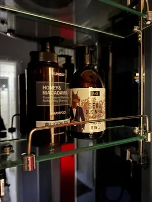 a glass shelf with two bottles of alcohol on it at Oscuro Deseo BDSM in Kaunas