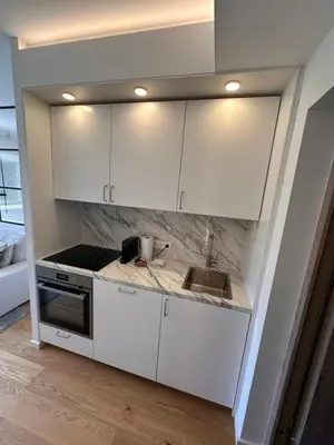 a kitchen with white cabinets and a sink at Algirdo Sunlight Studio in Vilnius