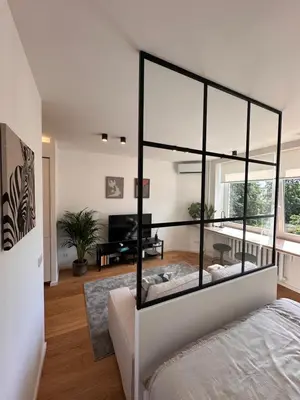 a bedroom with a bed and a living room at Algirdo Sunlight Studio in Vilnius