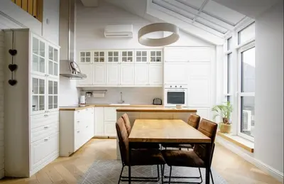 a kitchen with a wooden table and chairs at Urban Loft Escape Kaunas Center in Kaunas