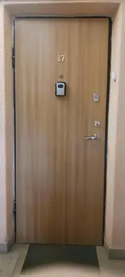 a wooden door with a camera on it at Gimnazijos apartamentai in Biržai
