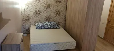 a small room with a bed and a wooden desk at Gimnazijos apartamentai in Biržai
