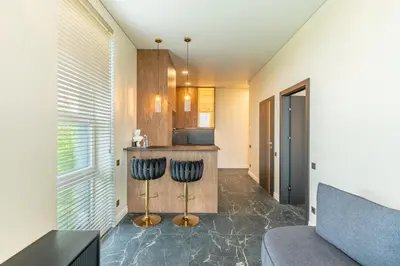 a kitchen with a counter and two stools in a room at Studija 17 rooms II in Kaunas