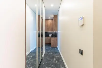 a hallway with a mirror and a kitchen at Studija 17 rooms II in Kaunas