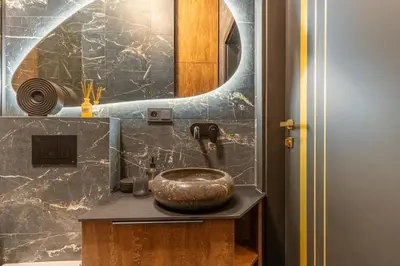 a bathroom with a stone sink and a mirror at Studija 17 rooms II in Kaunas