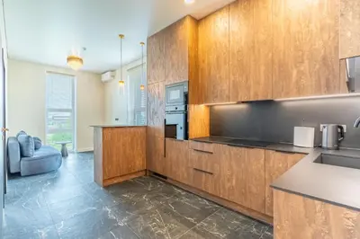 a kitchen with wooden cabinets and a sink at Studija 17 rooms II in Kaunas