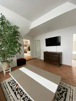 a living room with a table and a flat screen tv at Privatus Apartamentai Akademijoje in Akademija