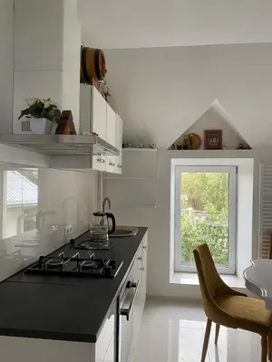 a white kitchen with a stove top oven next to a window at Privatus Apartamentai Akademijoje in Akademija