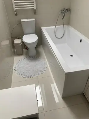 a white bathroom with a toilet and a bath tub at Privatus Apartamentai Akademijoje in Akademija