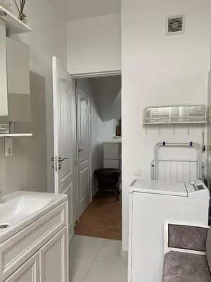 a white bathroom with a sink and a washer at Privatus Apartamentai Akademijoje in Akademija