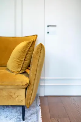 a brown couch with two pillows sitting in a room at French Park View Apartment in Vilnius