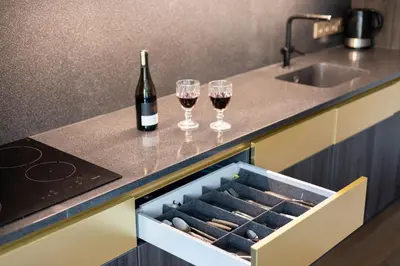 a bottle of wine and two wine glasses on a kitchen counter at French Park View Apartment in Vilnius