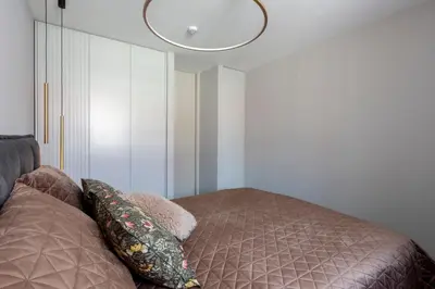 a bedroom with a bed and a ceiling light at French Park View Apartment in Vilnius