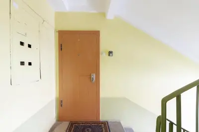 a staircase with a wooden door in a room at French Park View Apartment in Vilnius